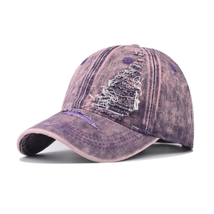 Close-up of purple washed denim baseball cap with distressed torn fabric and retro style