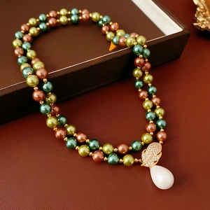 Dettaglio collana a due strati con perline, pendente a foglia dorata e perla a goccia