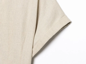 Close-up of linen dress sleeve showing fine stitching and natural cotton texture