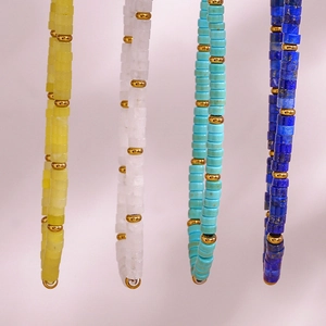 Detail of beaded jewelry sets in turquoise and deep blue with golden metal accents