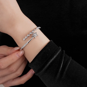 Macro shot of silver star bangle with cubic zirconia on model over black velvet