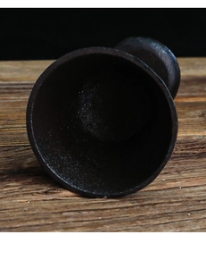 Vista superior de un recipiente de hierro fundido rústico sobre madera con textura granulada