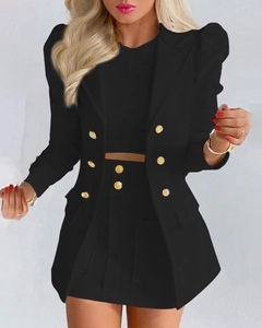 Détail d'un tailleur noir 2 pièces avec boutons dorés à double boutonnage et manches bouffantes