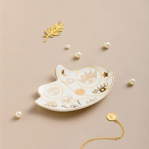 Dettaglio del vassoio per gioielli in ceramica bianca con motivi dorati di luna e stelle