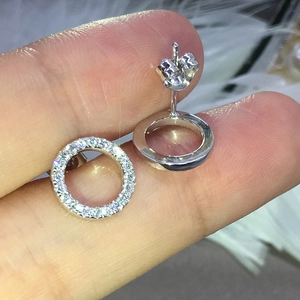 Detailed view of silver hoop earrings with round-cut cubic zirconia in hand