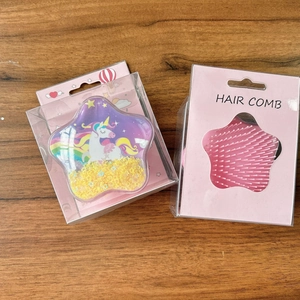 Detail of star-shaped hair comb with unicorn pattern and flowing yellow sequins in packaging