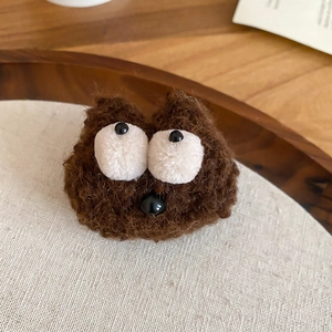 Detailed view of a handmade brown plush cartoon brooch with fuzzy texture and bead eyes
