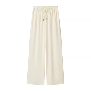 Dettaglio di pantaloni larghi color crema con elastico e coulisse in vita da donna