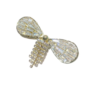 Golden butterfly hair clip with shimmering crystals and elegant tassel drop on white background