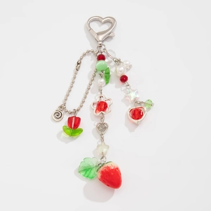 Dettaglio di ciondoli a fragola e tulipano su un portachiavi a cuore in argento perlato