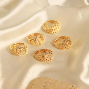 Detailed view of luxury hollowed gold rings with zircon inlay on premium silk background