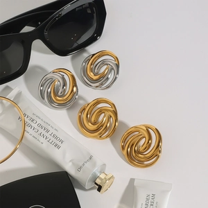 Detailed view of twisted knot stud earrings in 18k gold and silver two-tone stainless steel