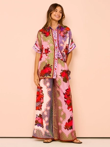 Detail of vibrant floral print shirt and wide-leg pants set with a modern collar design