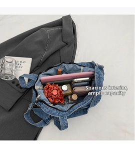 Macro detail of spacious interior in denim tote bag holding tablet and daily essentials
