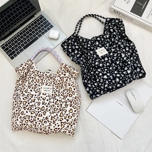Detailed top view of floral and leopard print canvas tote bags with woven rope handles