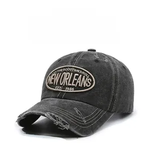 Detail of washed black baseball cap with New Orleans embroidery and distressed torn edges