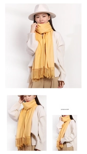 Detail of soft yellow faux cashmere scarf with elegant tassels on a female model