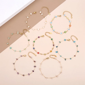 Set of eight gold chain bracelets featuring pearls, gravel stones and evil eye charms