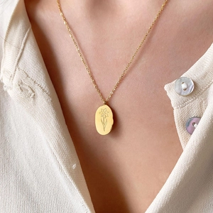 18K gold stainless steel oval flower necklace pendant worn on a beige sweater
