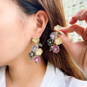 Exquisite gold floral drop earrings with colorful zircon stones on female model