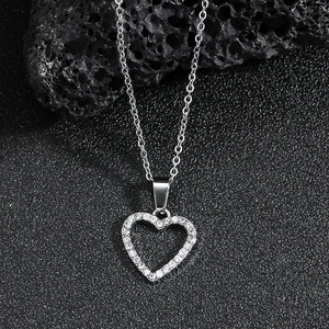 Chic silver hollow heart pendant necklace with shimmering crystals on dark stone