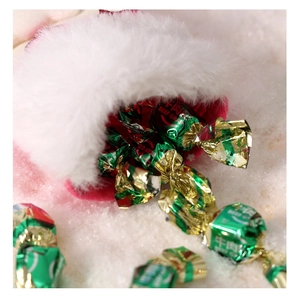 Vue macro de bonbons au bœuf sortant d'un bonnet de Noël rouge en peluche douce