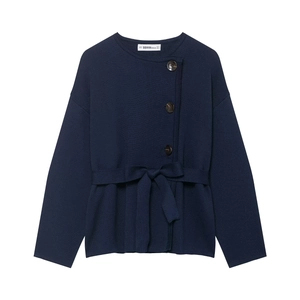 Detail of navy knit cardigan with button closure, waist tie, and fine fabric texture