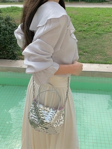 Sparkly silver sequin tote bag with chain strap shown in a stylish outdoor street fashion look