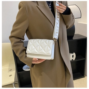 Detail view of a white quilted shoulder bag with patterned OYOX fabric strap