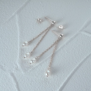 Detail of S925 hallmark on silver tassel earrings with white freshwater pearls