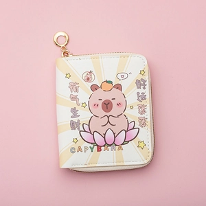Detailed macro view of cream-colored Capybara wallet with gold zipper and lucky charms