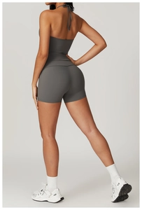 Macro detail of high-waist yoga shorts and halter open-back top in charcoal grey