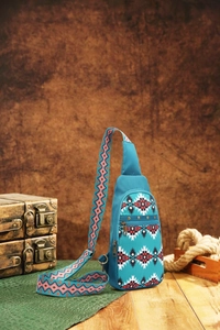 Detail of blue Aztec bohemian sling bag with tribal geometric print on wooden surface