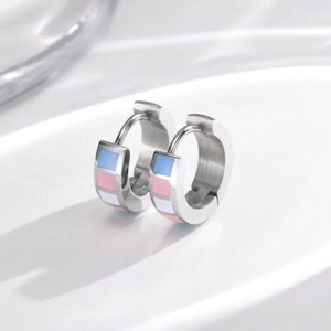 Macro view of silver stainless steel hoop earrings with transgender flag enamel inlay