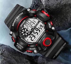 Macro shot of a black and red waterproof tactical sport watch on rugged outdoor wet rocks