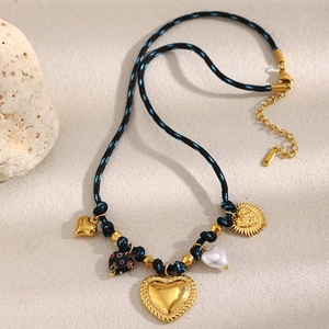 Detailed close-up of woven cord necklace with gold textured heart and sun pendants