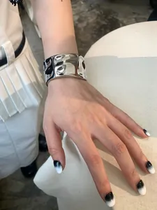 Detailed view of silver wide cuff bracelet with irregular wave texture on female wrist