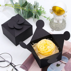 Top view of a black square paper gift box with a unique petal-shaped folding closure