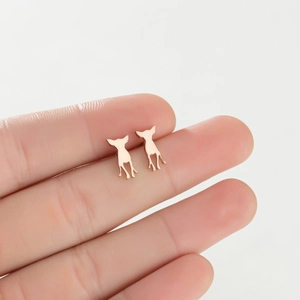 Close-up of minimalist rose gold stainless steel puppy studs held to show small size