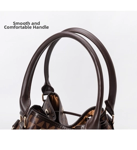 Detail of rounded brown leather handles with gold hardware on a printed bucket bag