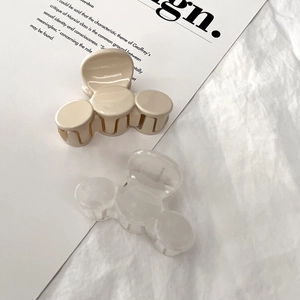 Detail of small beige and transparent hair claw clips on artistic background