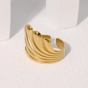 Macro shot of gold-plated stainless steel ring with stacked wing-shaped layered design