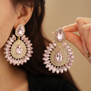 Macro shot of sparkling pink teardrop earrings with crystals on a female model