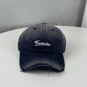 Gros plan détaillé sur le bord usé avec trous effilochés d'une casquette de baseball brodée
