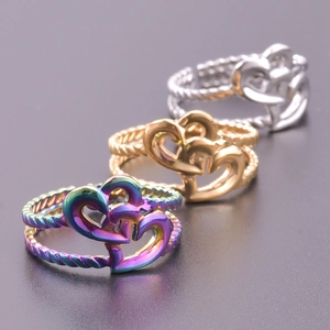Close-up of three interlocking heart rings in rainbow, gold, and silver finishes