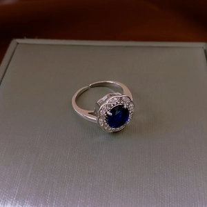 Macro di anello regolabile in argento con gemma ovale blu e alone di zirconi bianchi