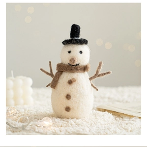 Close-up of wool felt snowman with black top hat and scarf for Christmas table decor