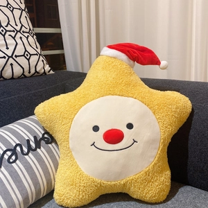 Nahaufnahme eines gelben Stern-Plüschkissens mit Smiley und festlicher Nikolausmütze