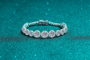 Macro shot of silver tennis bracelet with halo-set round moissanite stones and brilliant shine