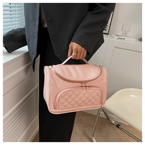 Pink cosmetic travel bag detail showing elegant quilted pocket and gold zipper hardware.